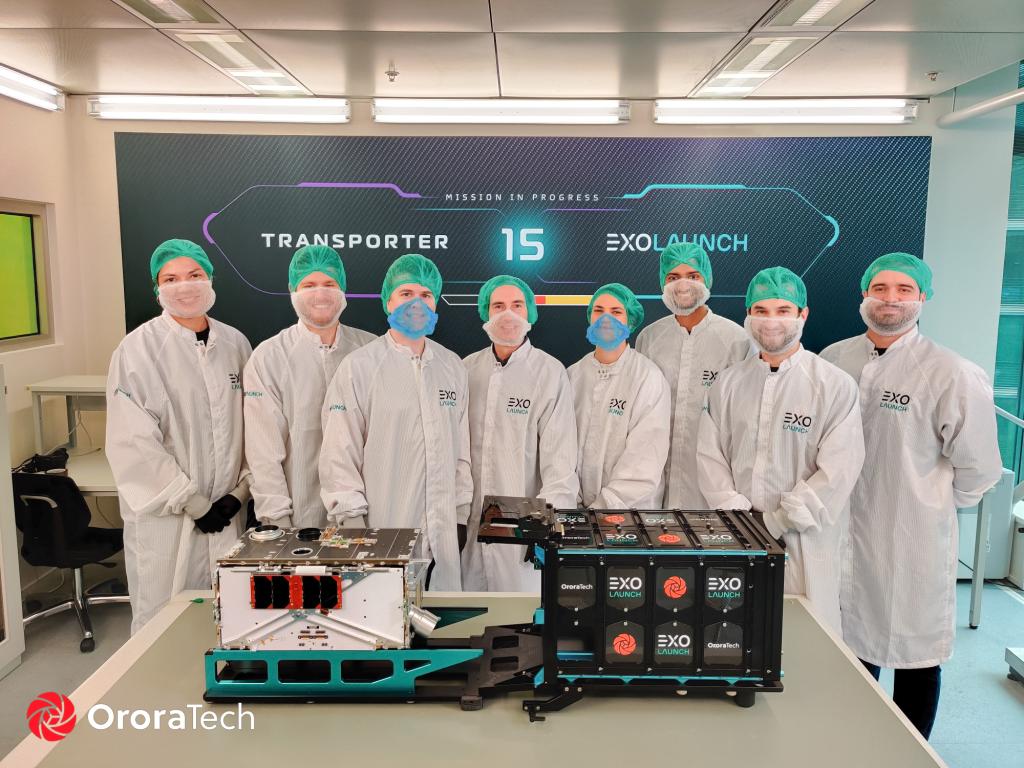 The OroraTech's engineers and project manager poses with GENA-OT during satellite packaging at Exolaunch.